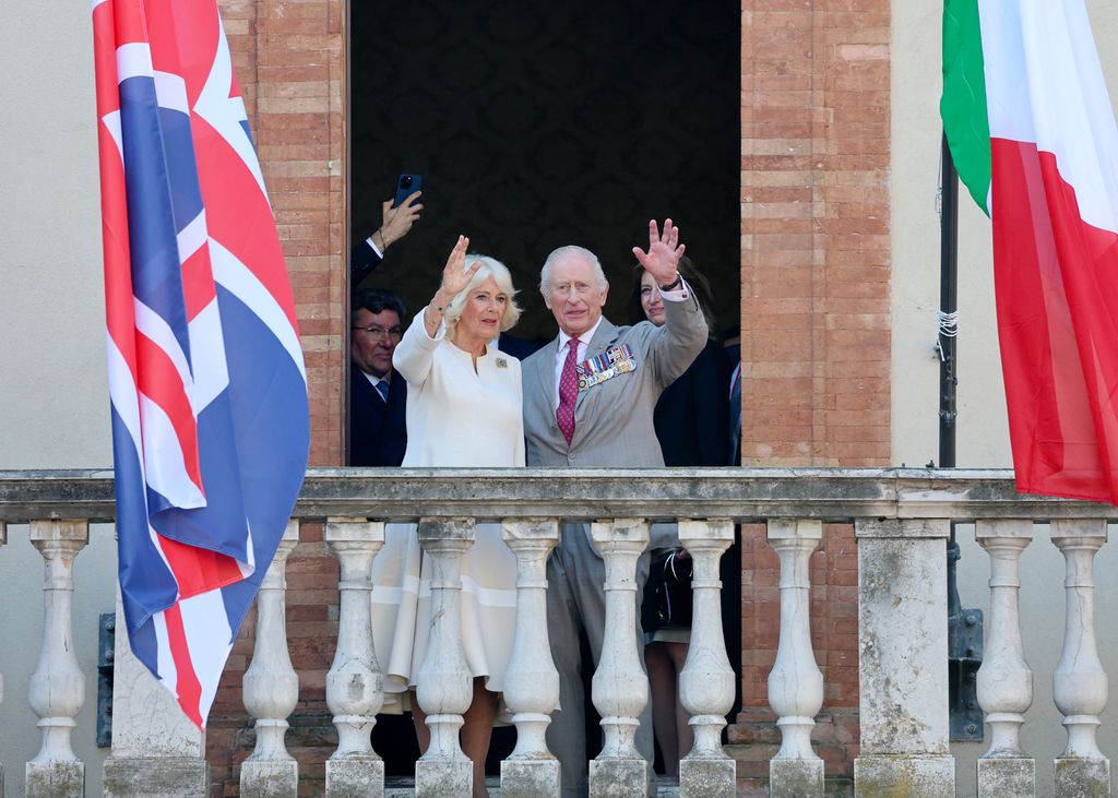 Britain's King Charles III and Queen Camilla wave from the balcony of the Town Hall of Ravenna, during the last day of a state visit to Italy