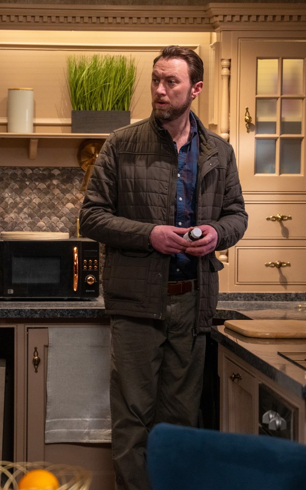 Liam Cavanagh checking a cupboard in a kitchen.