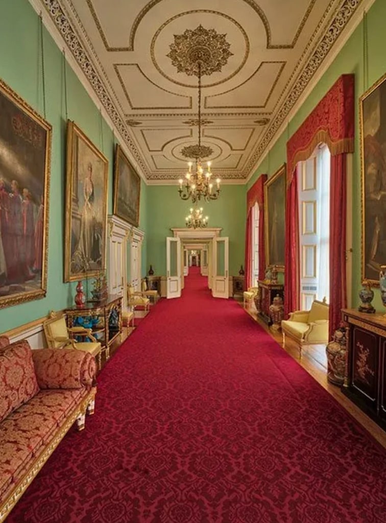 corridor with red carpet, green walls and luxury features