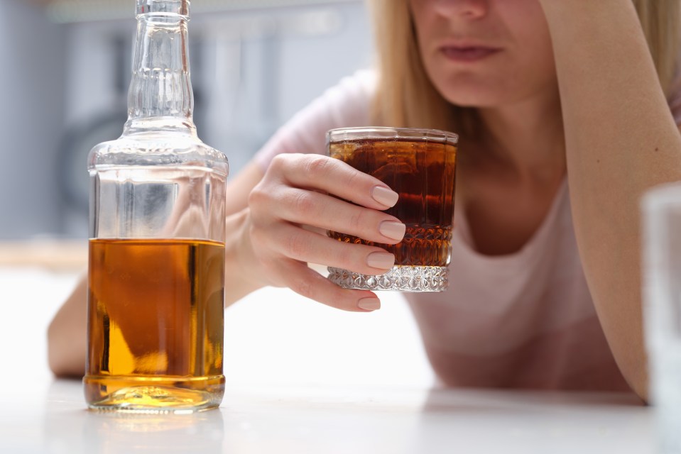 Woman holding a glass of whiskey.