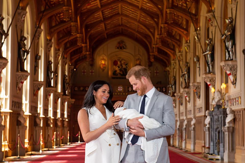 Britain's Prince Harry, Duke of Sussex (R), and his wife Meghan, Duchess of Sussex, pose for a photo with their newborn baby son, Archie Harrison Mountbatten-Windsor, in St George's Hall at Windsor Castle in Windsor, west of London on May 8, 2019.