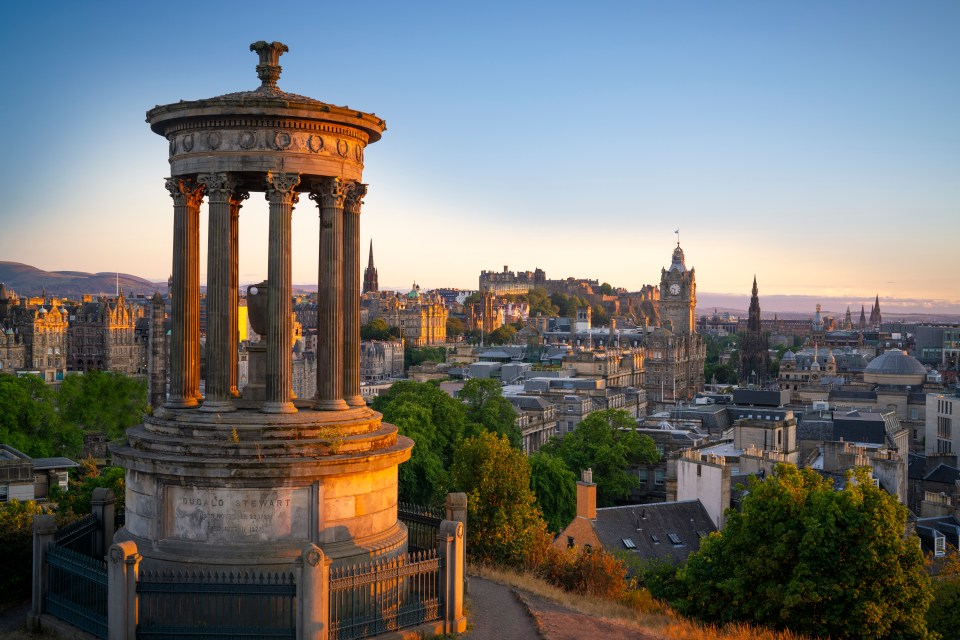 Aerial view of Edinburgh, Scotland at sunset, featuring the Dugald Stewart Monument and Edinburgh Castle.
