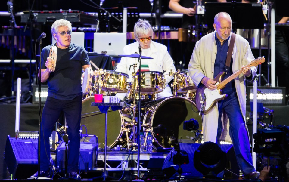 Roger Daltrey, Zak Starkey, and Pete Townshend of The Who performing live on stage.