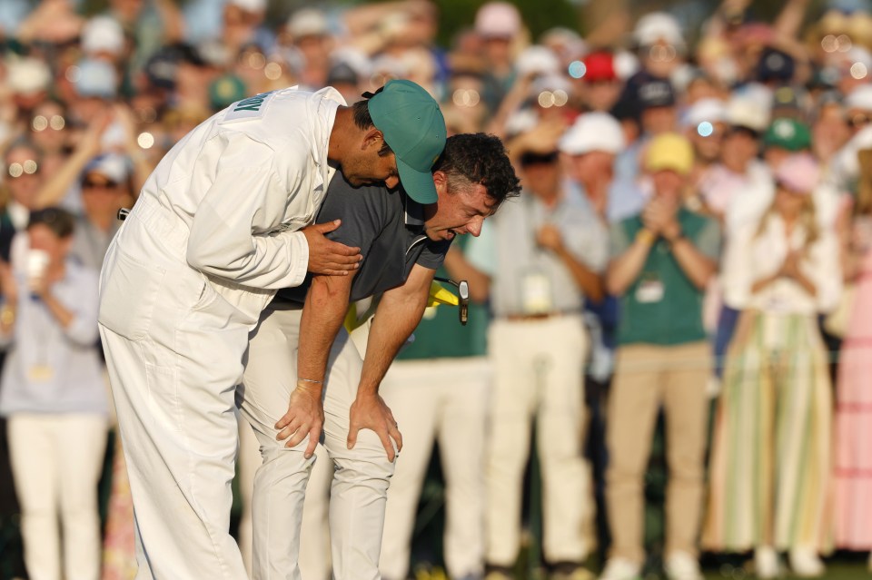 Rory McIlroy embraced by his caddie after winning a golf tournament.