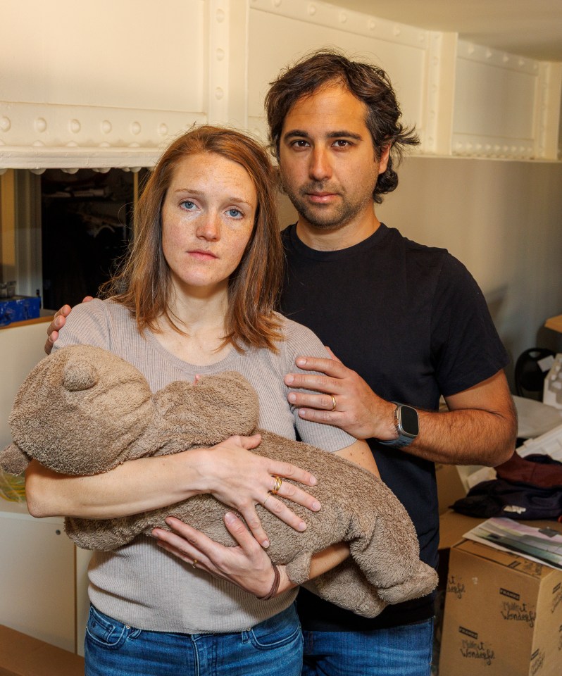 Parents holding their five-month-old daughter in their uninhabitable flat.