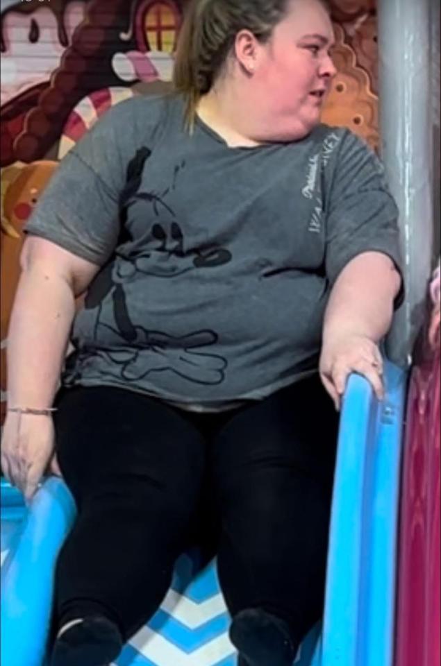 Woman sitting on a blue slide.