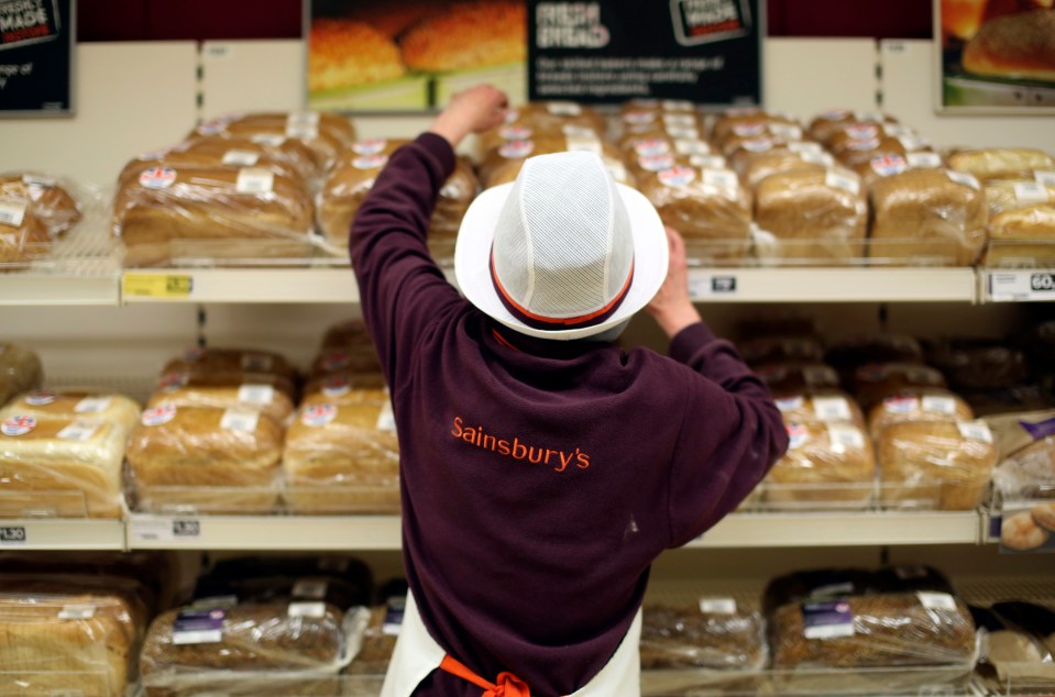 Sainsbury's employee stocking bread shelves.