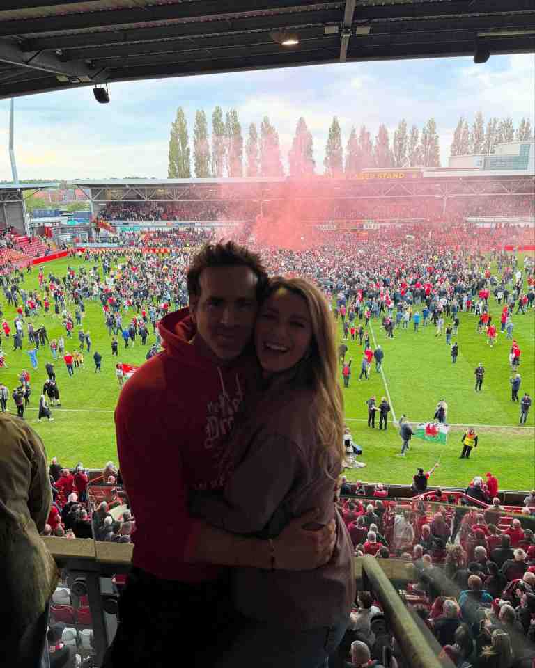 Ryan Reynolds and Blake Lively embracing at a soccer game.