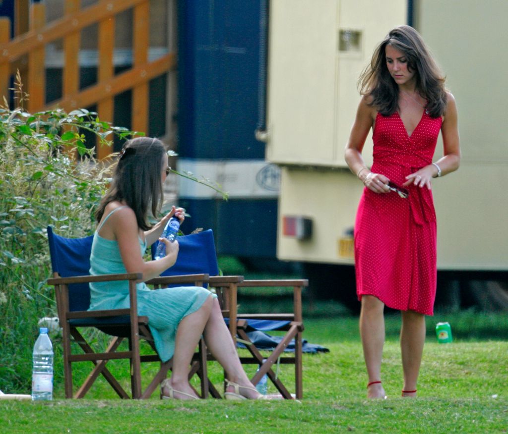 A photo of Kate Middleton wearing a red halterneck dress and Pippa Middleton wearing an aquamarine dress