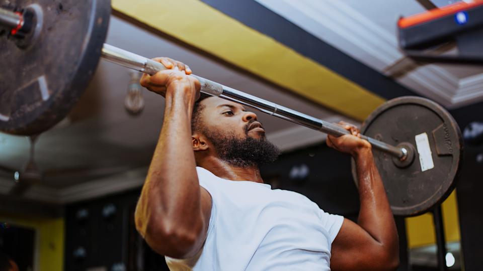  A man performing barbell overhead press. 