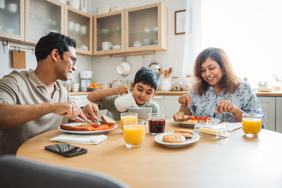Family of three enjoying breakfast together in their kitchen.