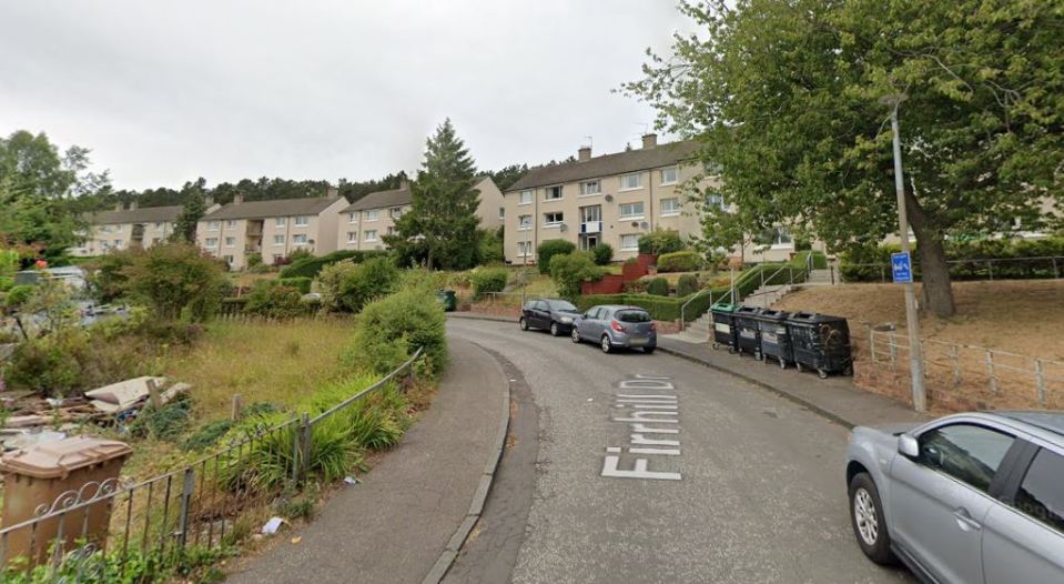 Firrhill Drive in Edinburgh, with apartment buildings and parked cars.