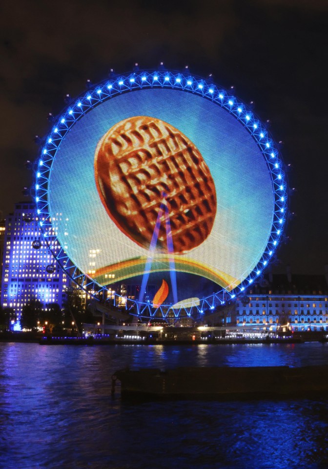 The London Eye illuminated with a projection of a chocolate digestive biscuit.