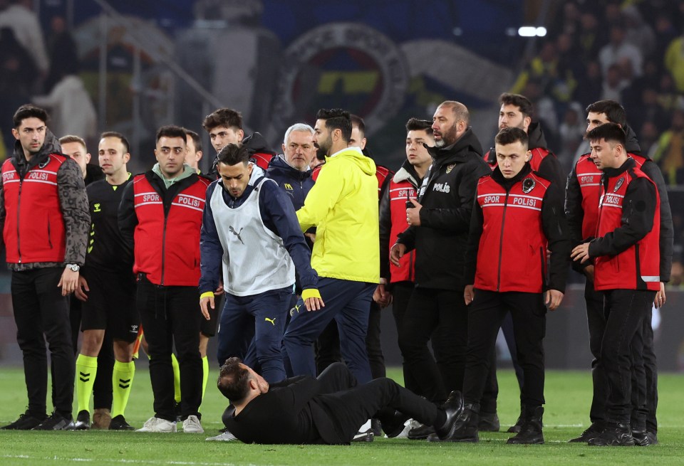 Galatasaray manager Okan Buruk on the ground after a confrontation.