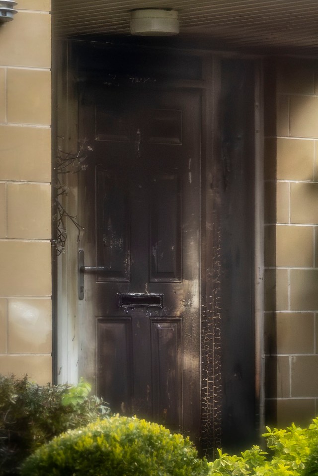 Charred front door after a fire.