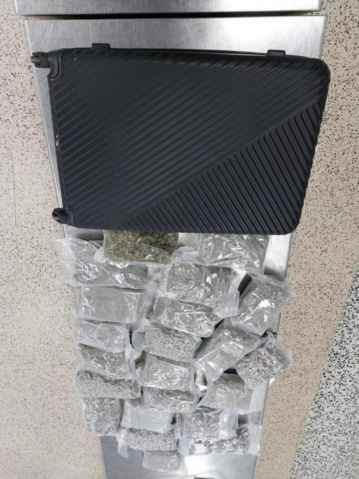 Suitcase and numerous bags of marijuana seized at an airport.