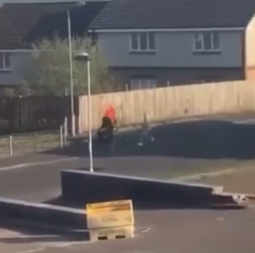 Two people fighting with large knives in a street.