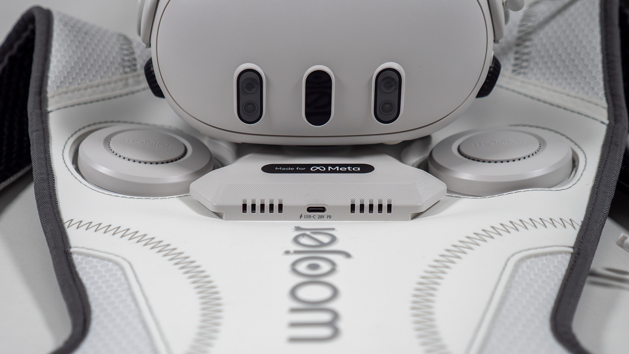 A Meta Quest 3 on top of the back of a Woojer Haptic Vest 3