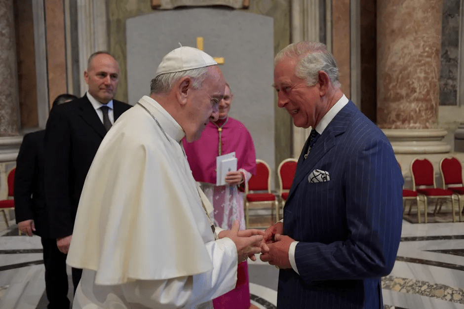 Pope Francis and King Charles III shaking hands.