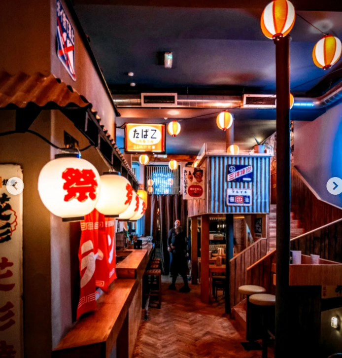 Interior of a Japanese restaurant with lanterns and vintage signage.