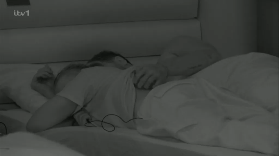 Two people cuddling in bed.
