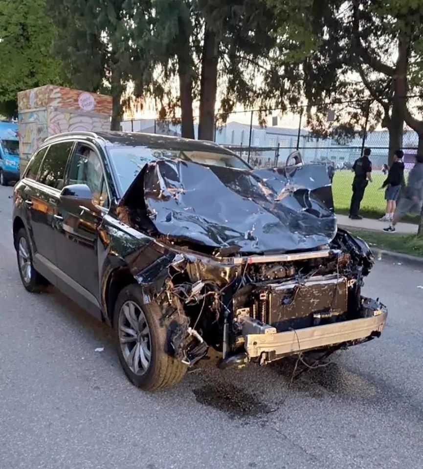 Severely damaged black SUV.