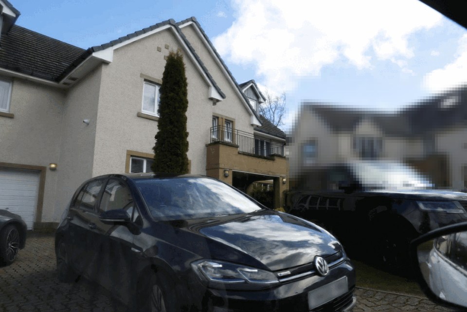 Black car parked in front of a house.