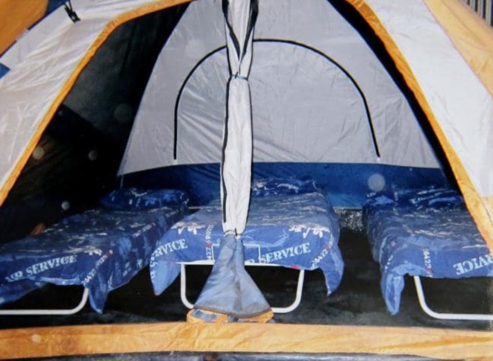 Interior of a tent with three cot beds.