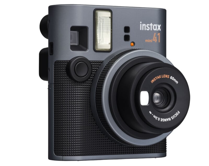 A gray Instax Mini 41 instant camera with a black textured grip, featuring a large lens and a built-in flash. The camera's branding and lens information are visible on the front.