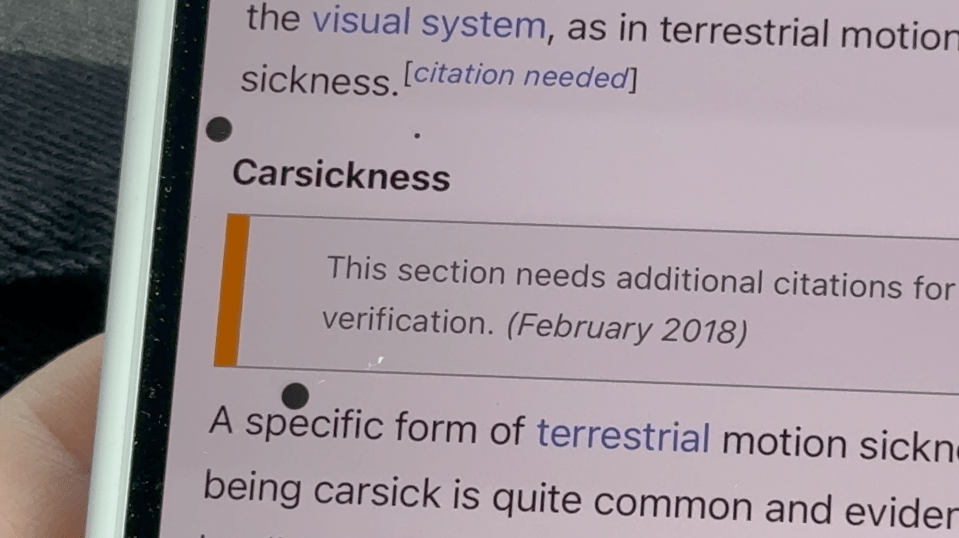 Close-up photo of a phone screen showing a Wikipedia article about carsickness.