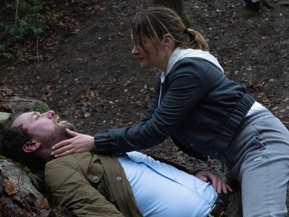 A woman cradles a man lying on the ground.