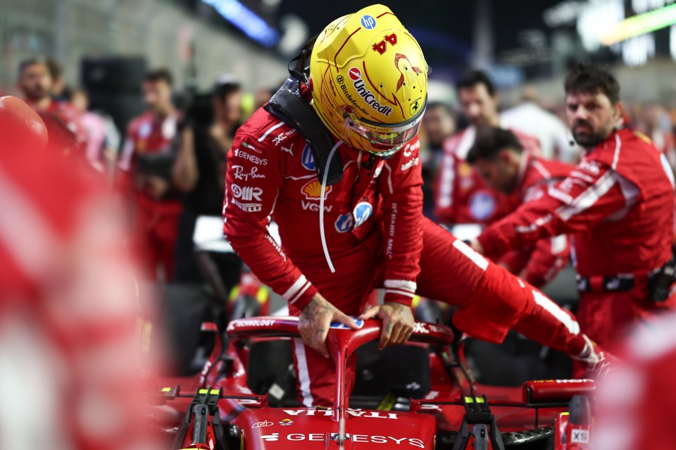Lewis Hamilton exiting his Ferrari race car.