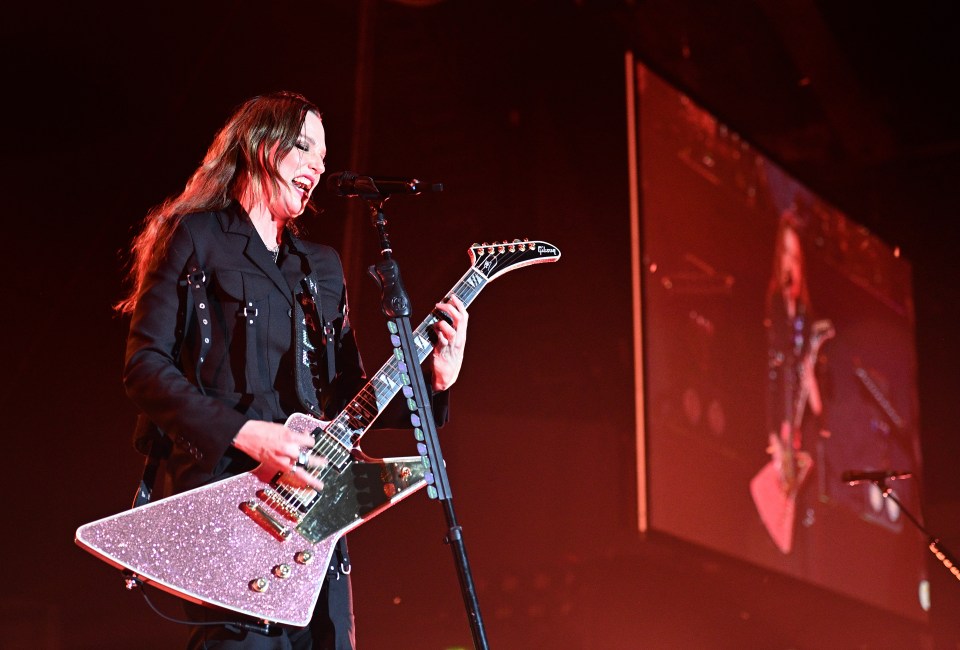 Lizzy Hale of Halestorm performing on stage with a guitar.