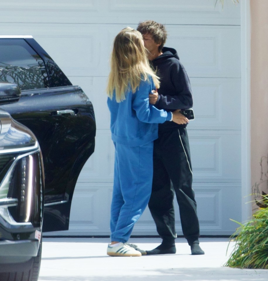 Louis Tomlinson and Zara McDermott kissing outside a house.