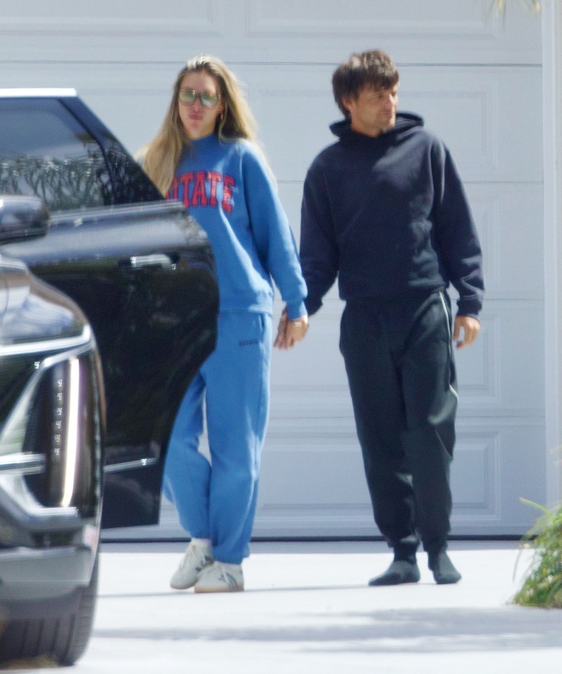 Louis Tomlinson and Zara McDermott holding hands outside an Airbnb.
