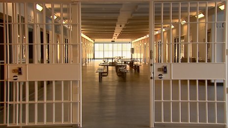 Interior view of a prison, showing cells and a common area.
