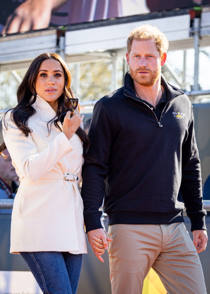 Meghan, Duchess of Sussex, and Prince Harry, Duke of Sussex, holding hands at the Invictus Games.