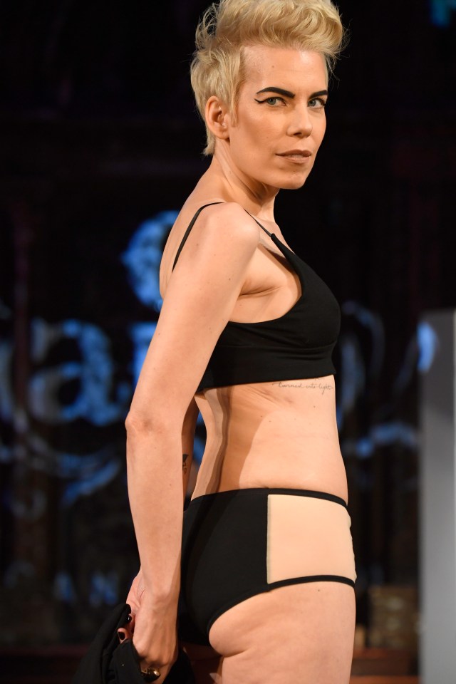 Model in black lingerie walking a runway.