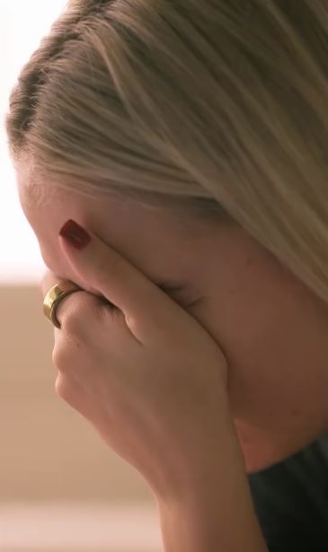 Woman covering her face with her hand.