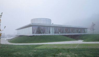 horizontal disk anchors office building by MVA on three greened mounds near zagreb