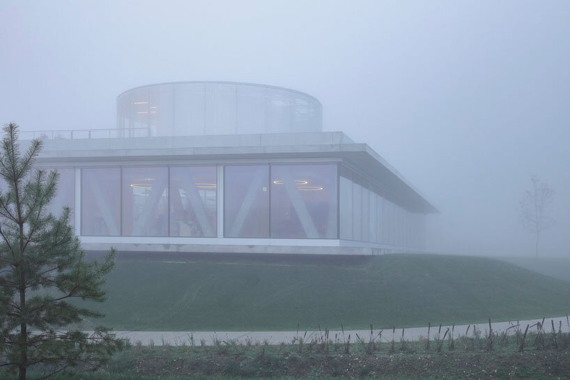 horizontal disk anchors office building by MVA on three greened mounds near zagreb