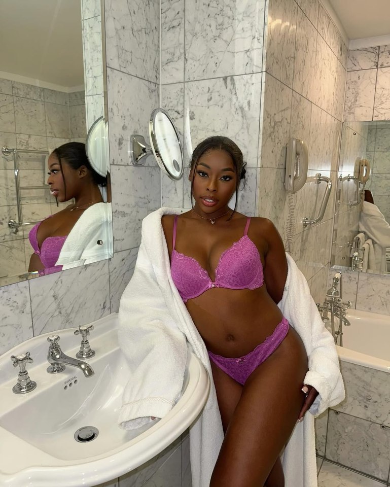 Woman in purple lingerie and white robe in a bathroom.