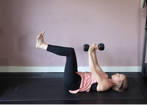 Woman performing a dumbbell exercise.