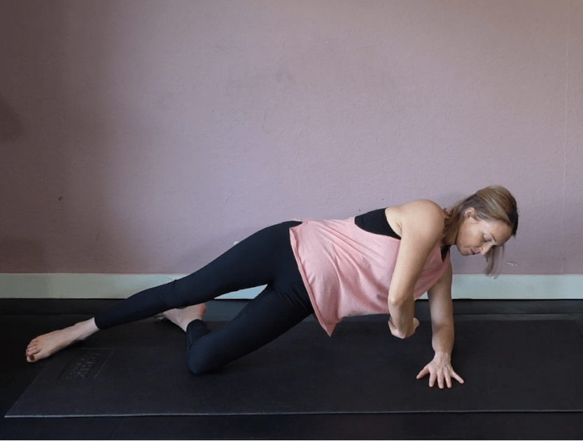 Woman demonstrating a side plank exercise.