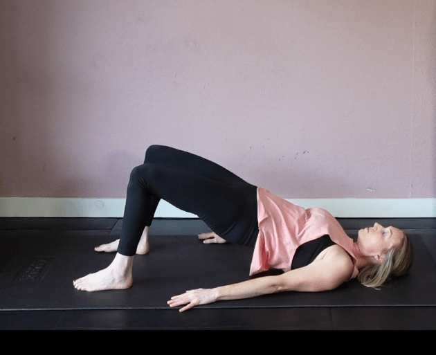 Woman performing a glute bridge exercise.