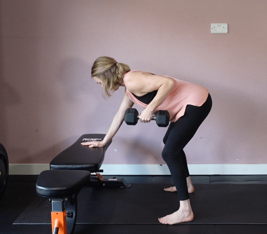 Woman performing a one-arm dumbbell row exercise.