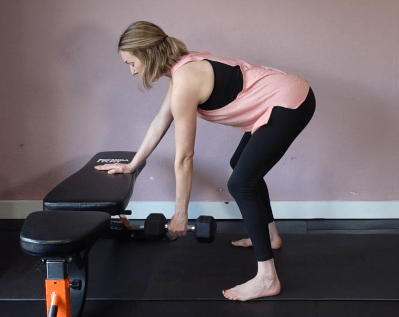 Woman performing a dumbbell row exercise.
