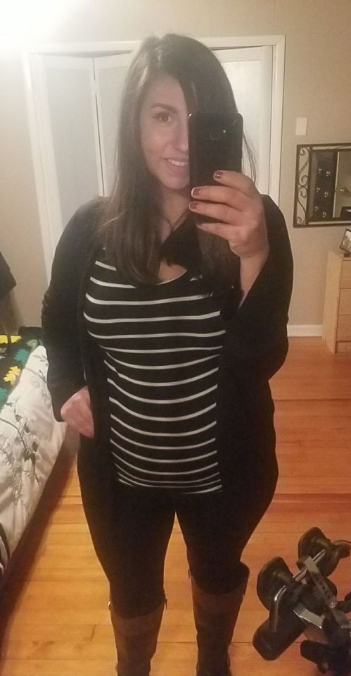 Woman taking a selfie in a striped shirt and black cardigan.