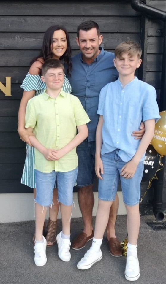 Family portrait of a mother, father, and two sons.