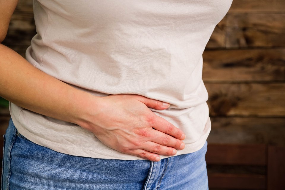 Woman holding her stomach in pain.